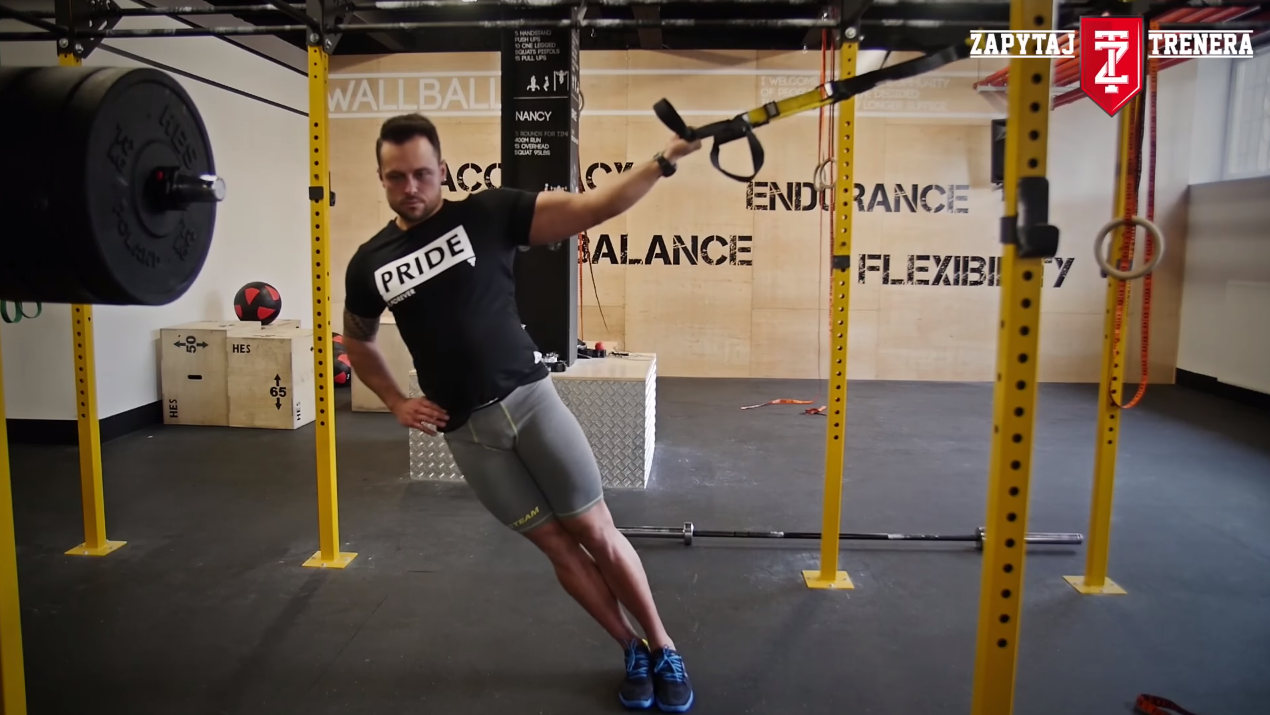Paweł Zontek pokazuje jak wykonać ćwiczenie na biceps przy pomoyc TRX