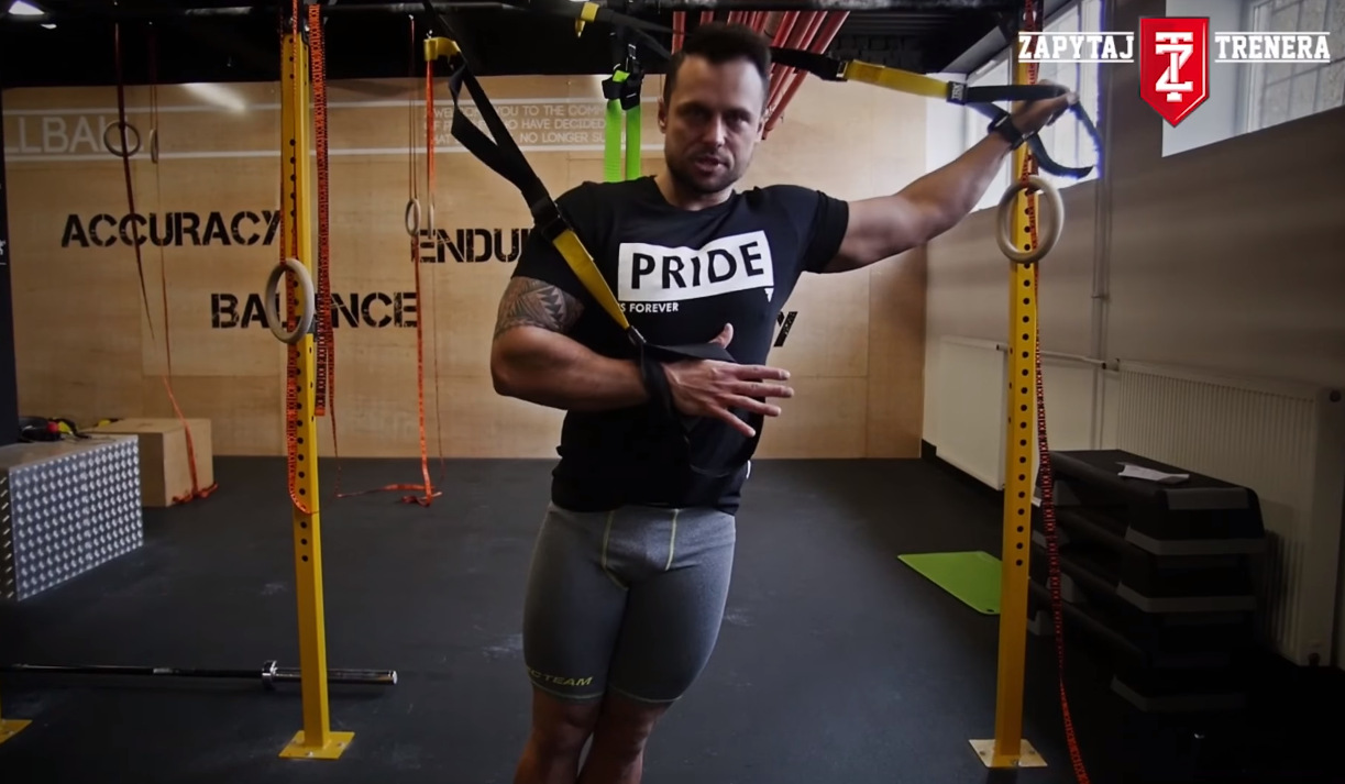 Paweł Zontek pokazuje jak poprawnie wykonać ćwiczenie na triceps przy użyciu taśm TRX